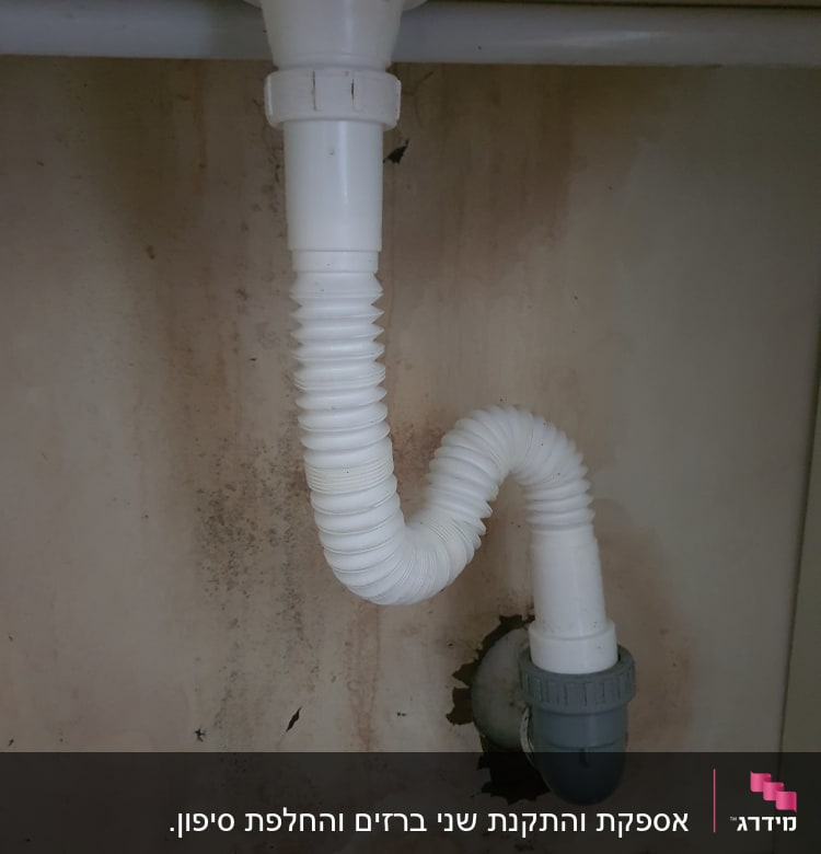 צינור ניקוז לבן מתחת לכיור עם חיבור אפור